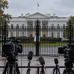 Closed White House gate with news cameras outside as the White House blocks CNN reporters